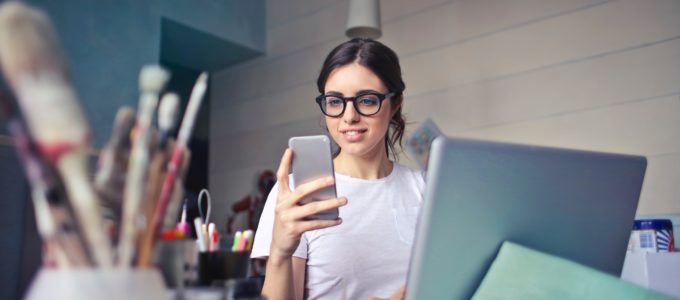 a female artist in her studio working on her phone